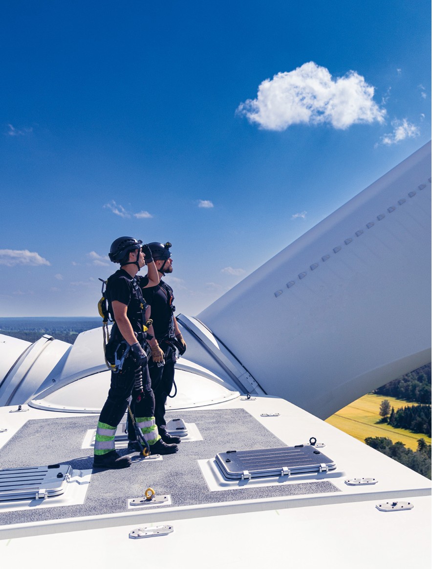 Pracownicy na szczycie turbiny wiatrowej